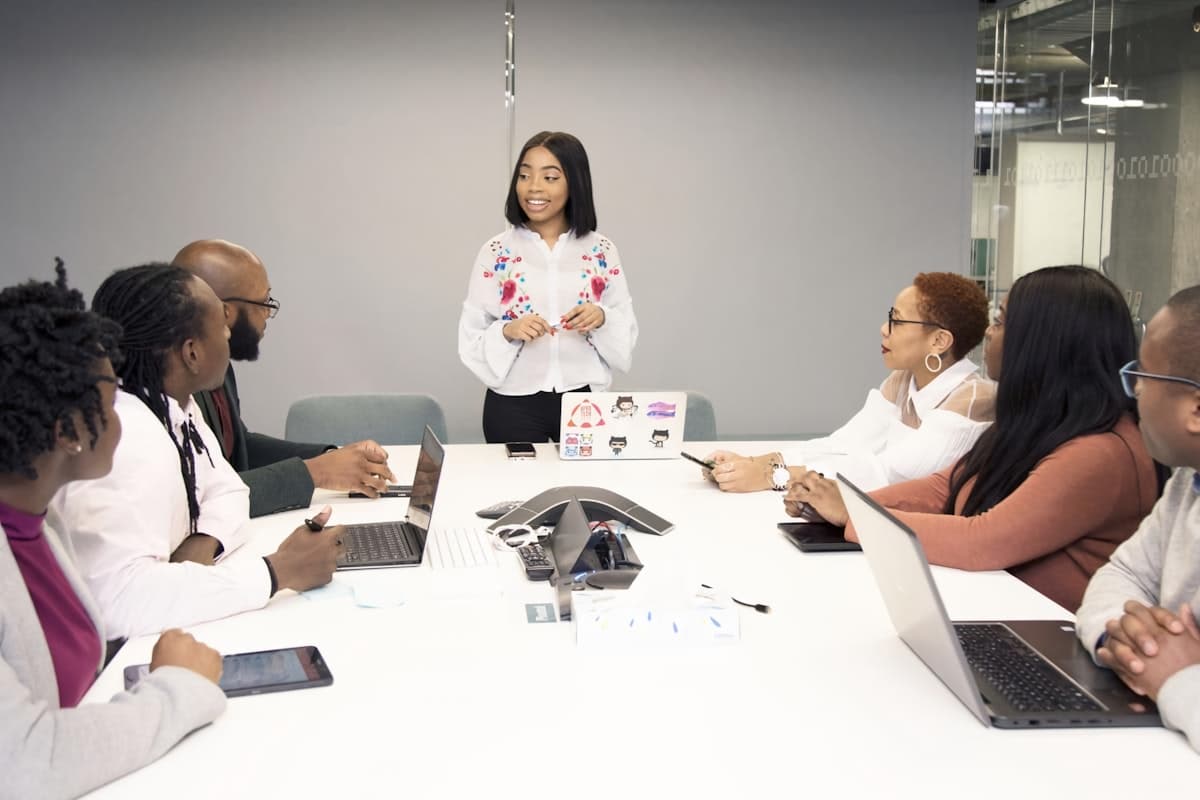 A colleague presenting to the team around a meeting-room table